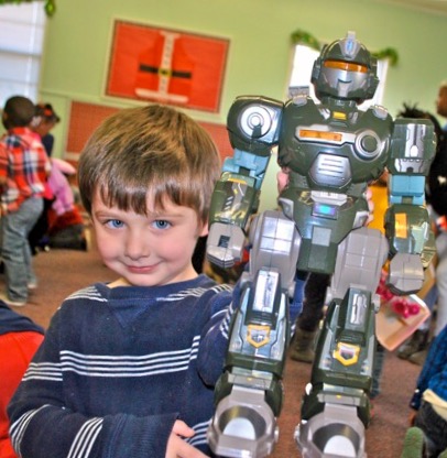 young boy holding a toy robot
