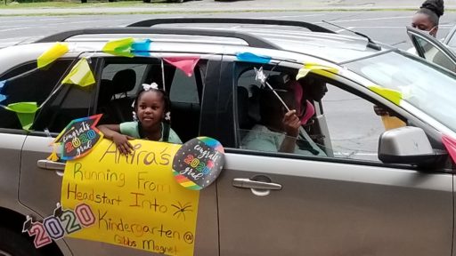 Child holding sign out car window