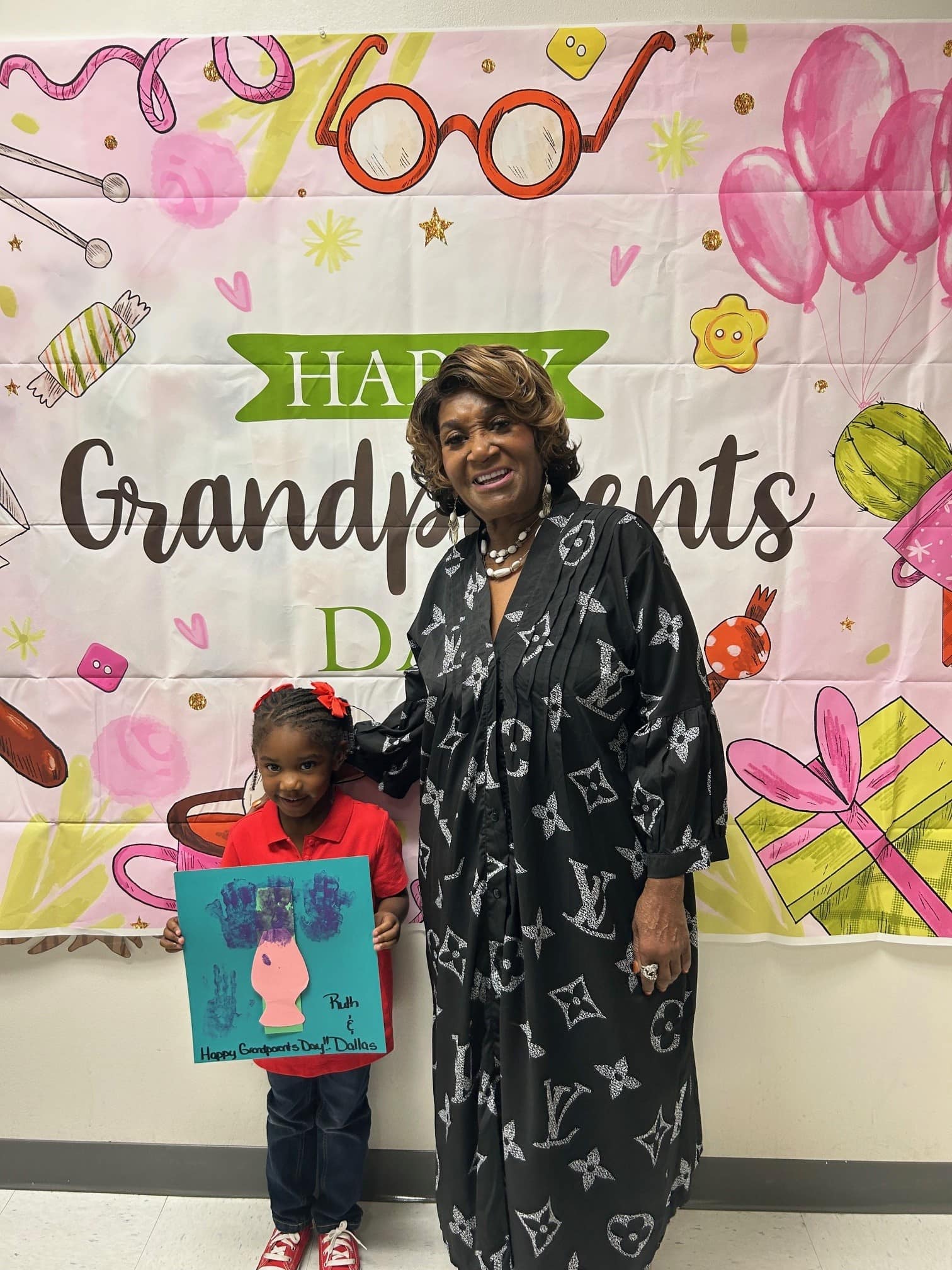 grandmother standing with grandson who is holding a picture they made