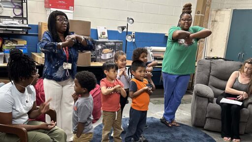 Teachers and students standing with their arms crossed in front of them