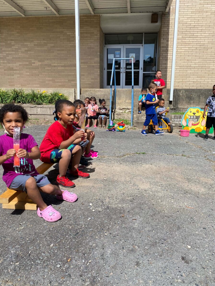 children sitting outside eating popsicles