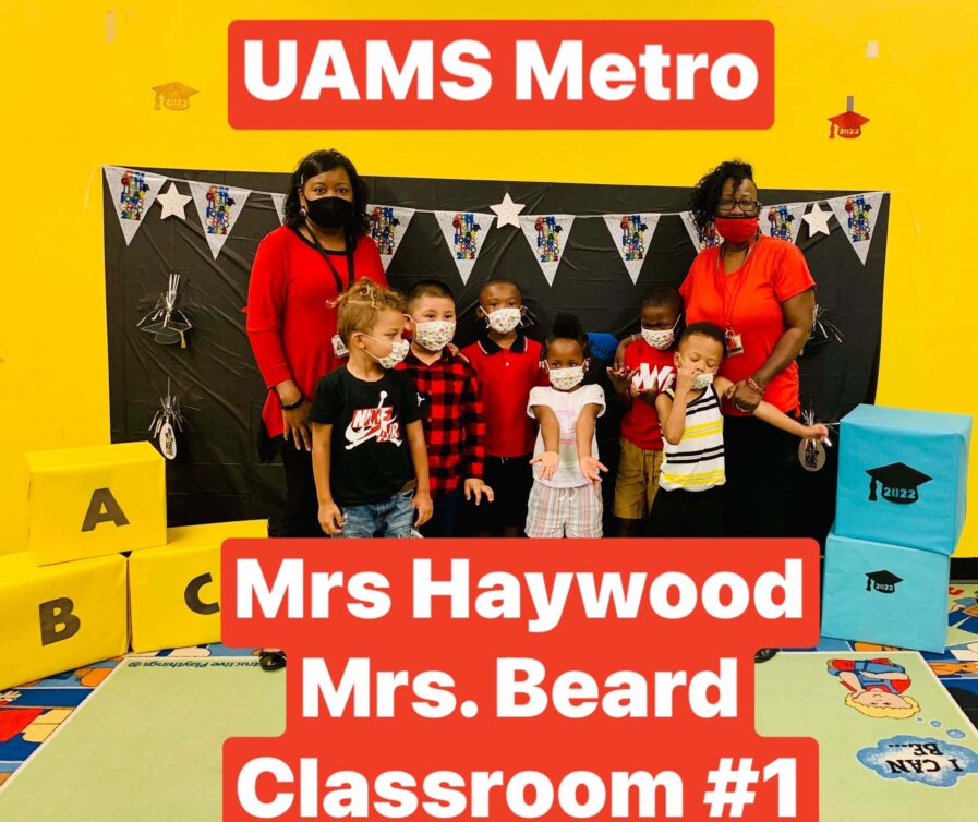 Children and staff rom classroom one pose for a picture with a caption saying UAMS Metro, Mrs. Haywood, Mrs. Beard Classroom #1