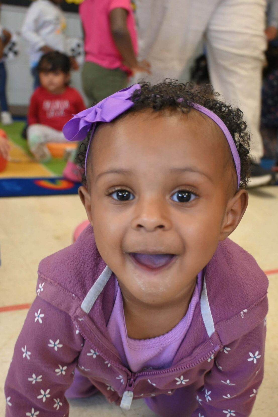 little girl in purple smiling for the camera