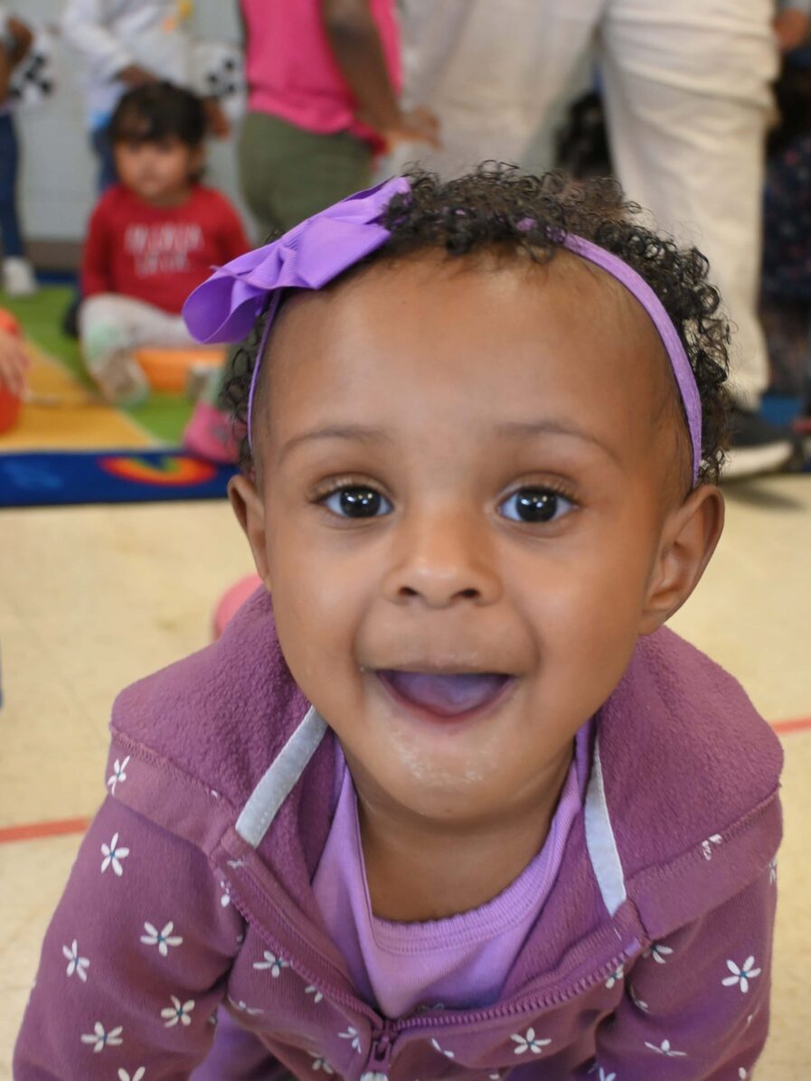 little girl in purple smiling for the camera