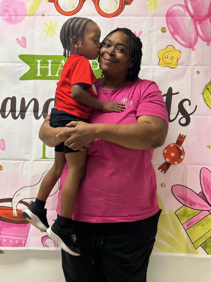 grandparent holding child and child kissing her on the cheek