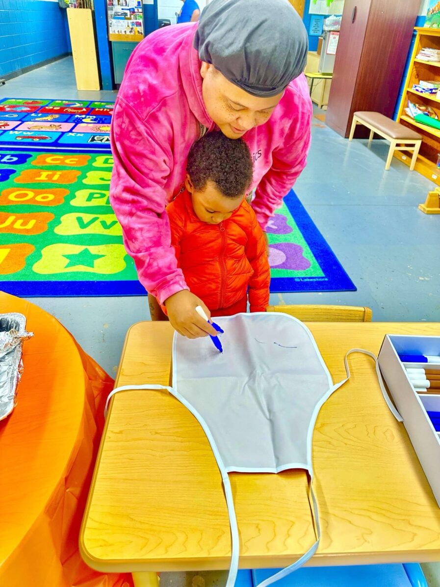 grandmother writing on apron with grandson