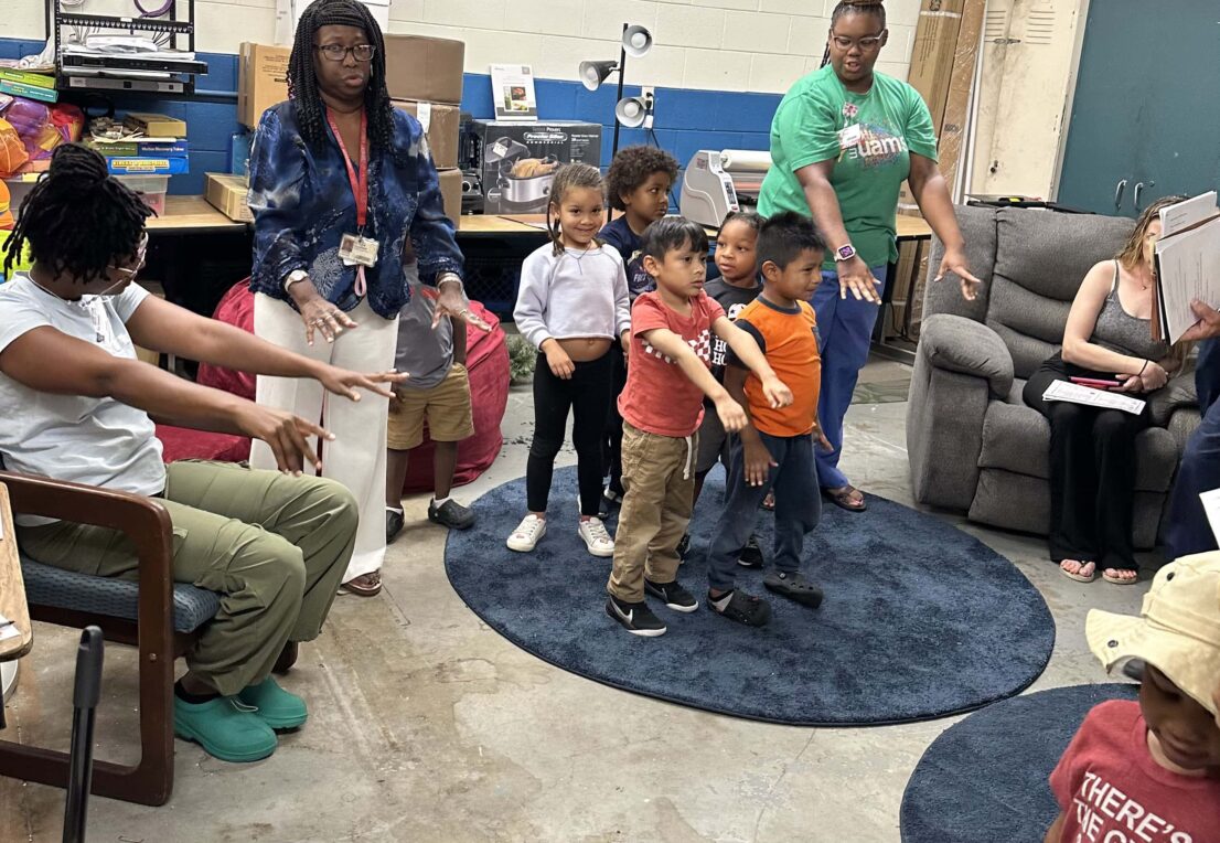 teachers and students holding their arms out