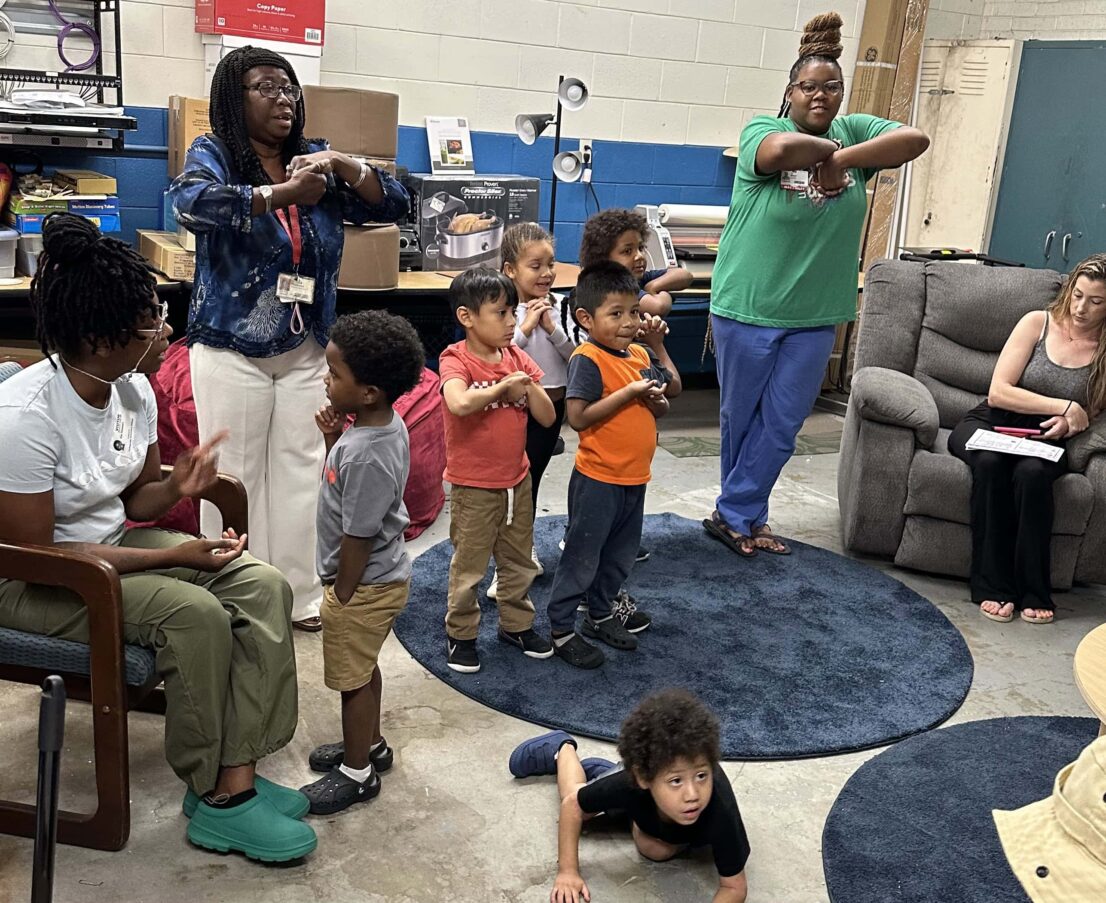 Teachers and students standing with their arms crossed in front of them