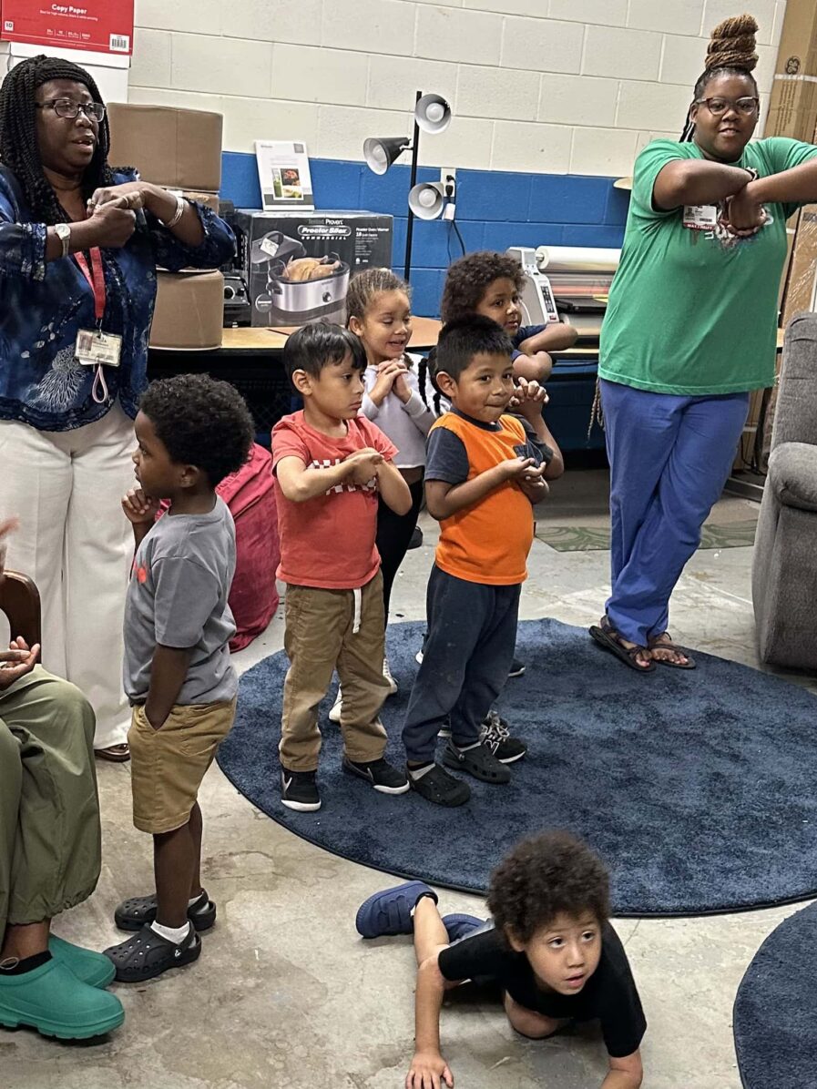 Teachers and students standing with their arms crossed in front of them