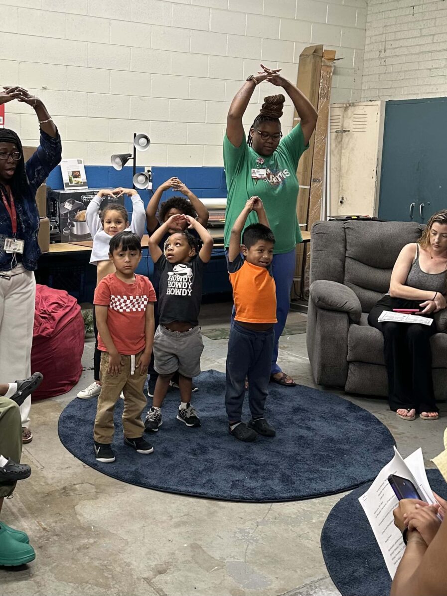 teachers and students standing with their arm above their heads