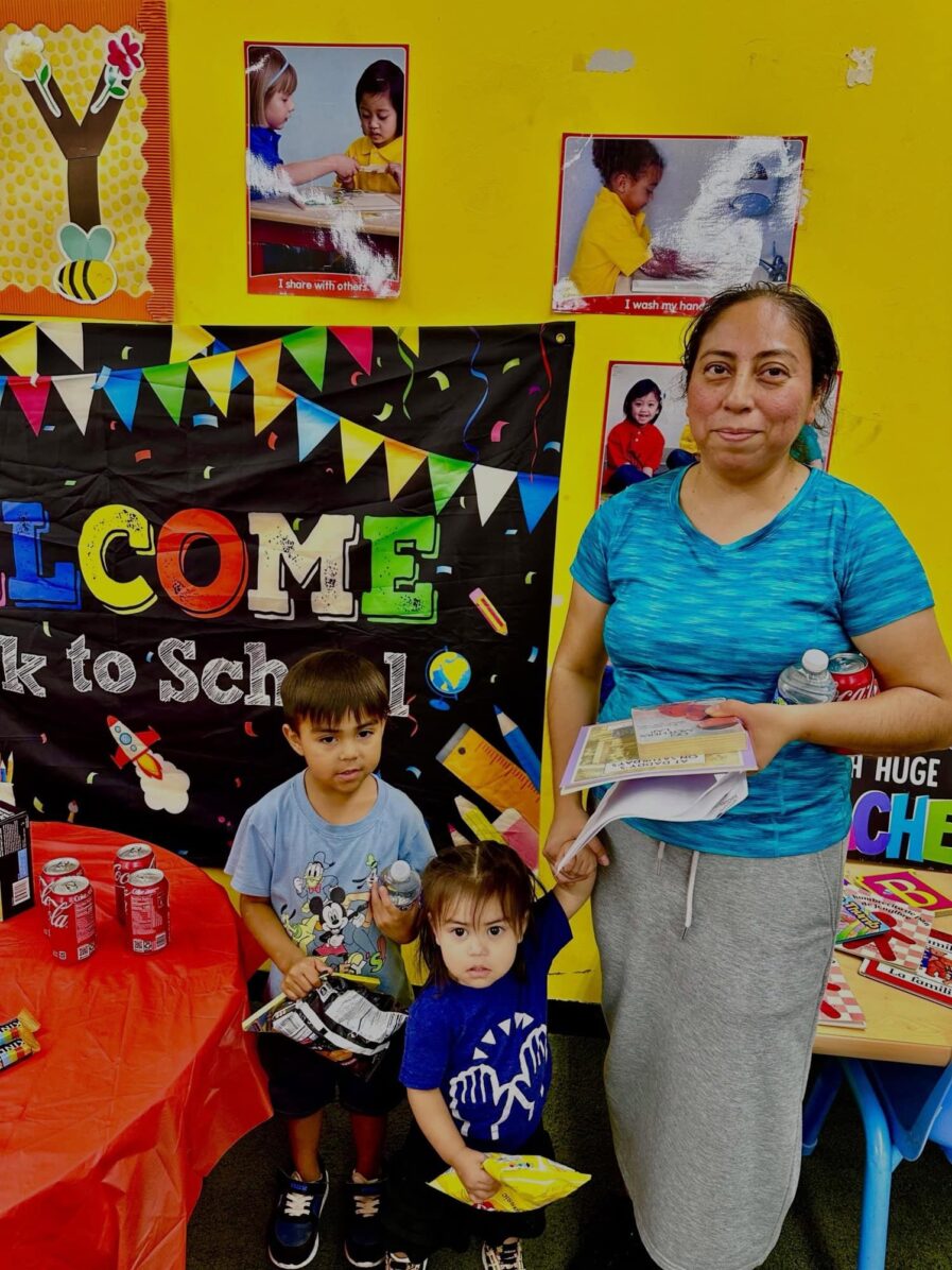 a woman poses with two young children a girl and a boy