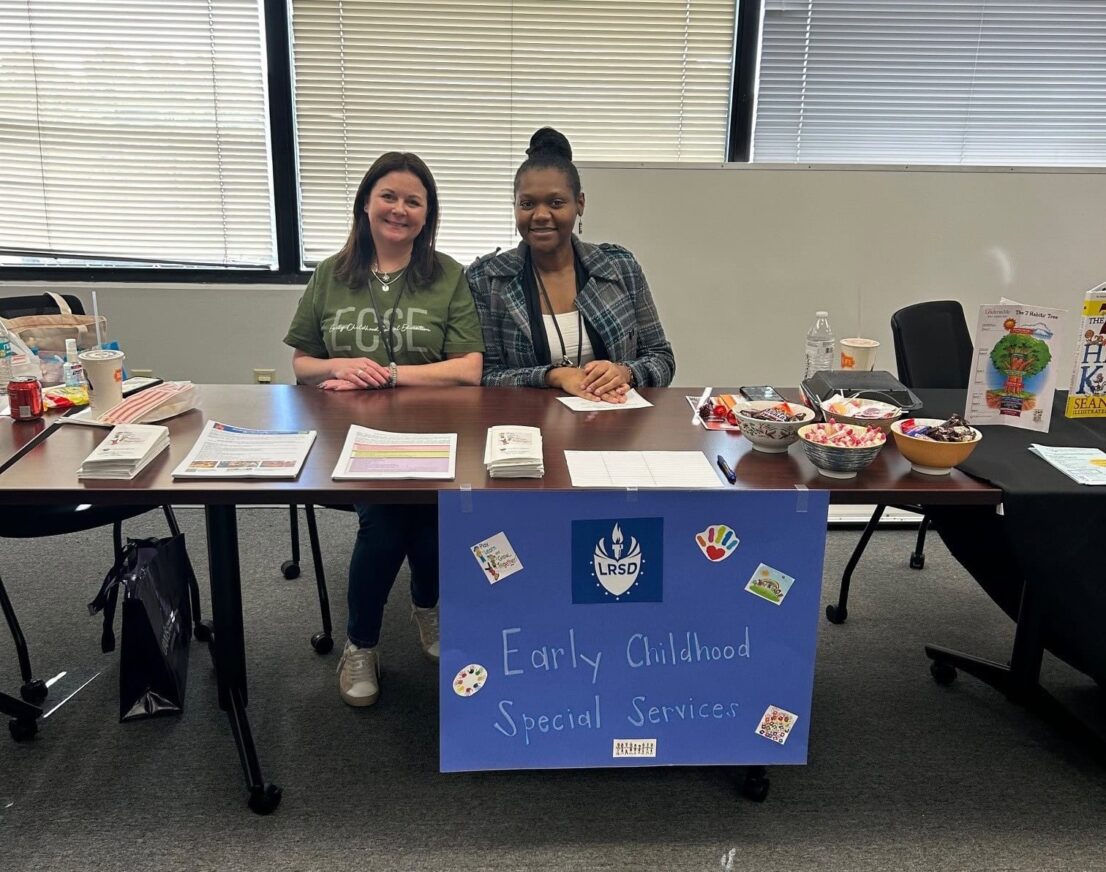 Two women from Early Childhood Special Services from Little Rock School District are sitting at a table waiting to answer any questions families might have.